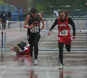 NaTosha Schaeffer finishes second in the 300 hurdles final in the rain as one of the other competitors crashes over the final hurdle.