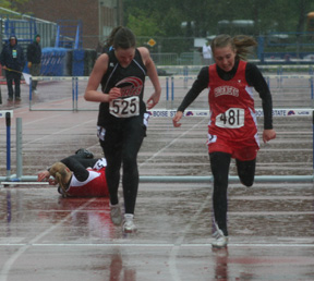NaTosha Schaeffer finishes second in the 300 hurdles final in the rain as one of the other competitors crashes over the final hurdle.