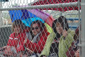 Sherry Holthaus, Theresa Schmidt and Verla Wilson tried to stay warm and dry during the Greenleaf game on Saturday.