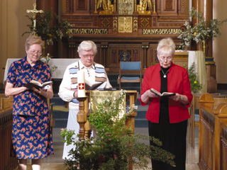 From left: Sisters Placida Wemhoff and Carol Ann Wassmuth renew their monastic vows in the Monastery of St. Gertrude chapel, with Prioress Clarissa Goeckner presiding.