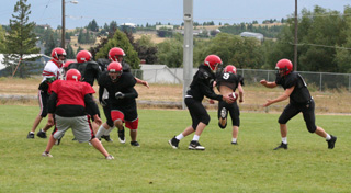 The first team offense runs a play during practice Monday. Thats quarterback Beau Schlader, whos sprouted up to 62, handing off to Devin Schmidt. #9 is Brock Heath.