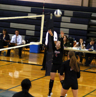 Megan Sigler sets the ball as MeShel Rad gets ready to go for the spike.