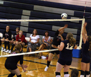 Shelby Duman spikes the ball over the next against Grangeville. At left is Kayla Johnson.