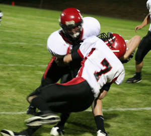 Garrett Schmidt and Beau Schlader combine on this tackle of a Deary ballcarrier. At right is Colton Nuxoll.