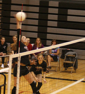 MeShel Rad pounds the ball in the Highland match. Also shown is Tanna Schlader.