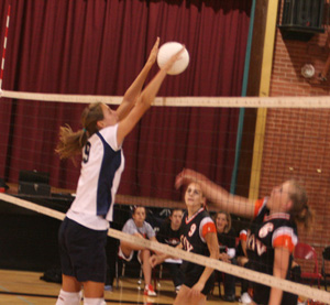 Savanah Prigge blocks a Troy spike. At left is Nicole Frei.