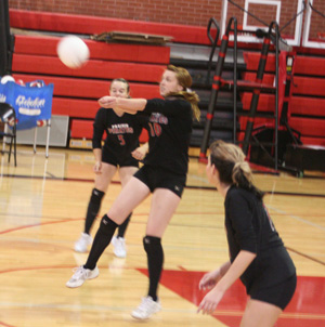 Kayla Johnson makes a pass from the back row as Monica Lustig and Sam Poxleitner watch.