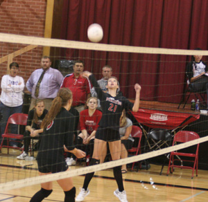 Sam Poxleitner winds up for a kill against C.V. as MeShel Rad watches.