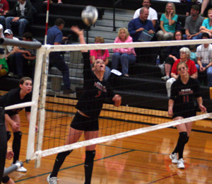 MeShel Rad spikes the ball at Timberline as Sam Poxleitner and Tanna Schlader watch.