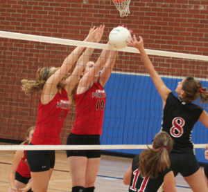 Shelby Duman and Kayla Johnson stuff a Deary player at the net. Behind them is Tanna Schlader.