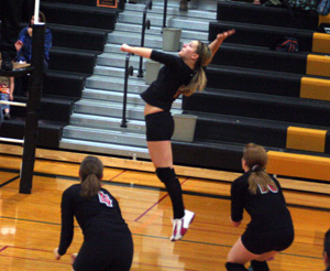 Shelby Duman leaps for a spike at Timberline as Megan Sigler and Kayla Johnson watch.