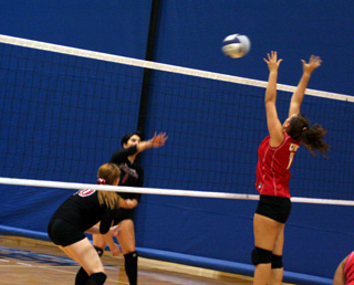 Fran Johnson spikes the ball against C.V. At left is Kayla Johnson.