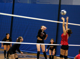 Kayla Johnson spikes the ball against C.V. as from left Fran Johnson, Megan Sigler and Sam Poxleitner watch.