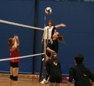 MeShel Rad is about to slam the ball in the C.V. match. Also shown are Megan Sigler and Fran Johnson.