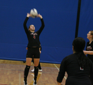 Megan Sigler set the ball in the Troy match. At right are Fran Johnson and Kayla Johnson.