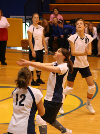 Rachael Frei makes a set as Jamie Chmelik and Savanah Prigge watch during Summits District match against Highland.