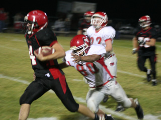 Devin Schmidt pulls away from a tackle attempt. In the background is Colton Nuxoll.