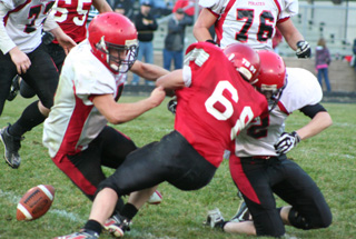 Devin Schmidt and Seth Guyer team up to tackle Nathan Cook as the ball comes loose.