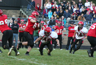 Garrett Schmidt is about to wrap up the legs of Wallaces Nathan Cook as he makes the tackle. At right is Justin Schmidt.