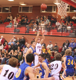 Devin Schmidt puts up a jump shot as Troy Lorentz, 10, and Justin Schmidt, 20, battle for rebound position.