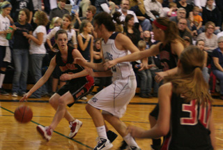MaKayla Schaeffer handles the ball against Grangeville. At right are MeShel Rad and Tanna Schlader, 30.