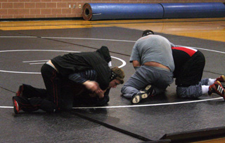 Prairie wrestlers practiced Monday at the Elementary gym. Kade Perrin and Damien McWilliams go at it on the left while assistant coach Justin Nuxoll gives heavyweight Mitch Jungert someone his own size to scrimmage against.