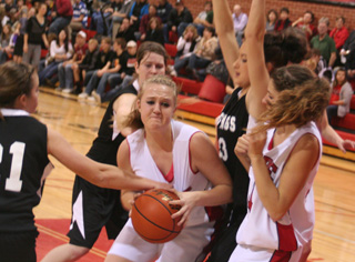 Kendal Schumacher has a determined look on her face as she battles in the lane against Deary (and appears to get fouled as #21 gets a hand full of uniform). At right is Shelby VonBargen.