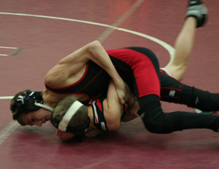 Alex Duman hooks an arm of a Wallace wrestler as he attempts to roll him over for a pin. Duman took 2nd in the 112 lbs. class.