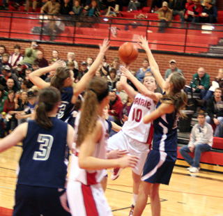 Megan Sigler attempts to shoot over Savanah Prigge. Other Summit players are Nicole Frei, 3, and Brooke Schumacher. Also shown for Prairie is MeShel Rad.