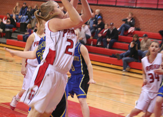 Kendal Schumacher goes for a lay-up against Genesee. At right is Shelby VonBargen.