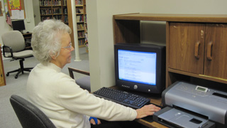 Laurine Nightingale, volunteer librarian, is working on the computer at the Prairie Community Library.