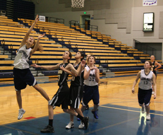Savanah Prigge puts up a shot against Timberline. Also shown are Megan Rehder, 32, and Rachel Wemhoff.