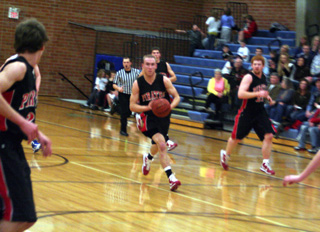 Devin Schmidt looks to pass to Justin Schmidt, left, who wound up with a lay-up in the Genesee game. At right is David Johnson while behind Devin is Seth Guyer.