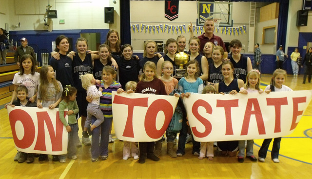 The Summit Academy team with a lot of young fans after winning the District title at Nezperce Saturday. Savanah Prigge is kneeling third from right in front. Other players from left are Megan Rehder, Brooke Schumacher, Rachael Frei, Kayla Duclos, Cassidee Stubbers, Rachel Wemhoff, Sarah Chmelik, Jamie Chmelik,  Abi Chmelik, Nicole Wemhoff and Nicole Frei. In back are coaches Alexia Prigge and Pete Prigge. Photo supplied by Summit Academy.