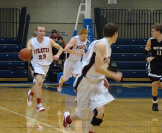 Devin Schmidt heads for the Prairie hoop on a fast break with Seth Guyer leading and David Johnson trailing. Photo by Kayla Raymond.