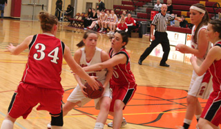 Megan Sigler fights through traffic in the Challis game. At right is MeShel Rad.