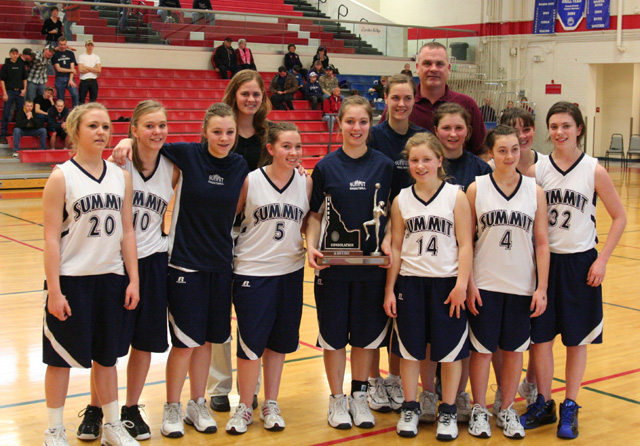 The Summit Academy team with a lot of young fans after winning the District title at Nezperce Saturday. Savanah Prigge is kneeling third from right in front. Other players from left are Megan Rehder, Brooke Schumacher, Rachael Frei, Kayla Duclos, Cassidee Stubbers, Rachel Wemhoff, Sarah Chmelik, Jamie Chmelik,  Abi Chmelik, Nicole Wemhoff and Nicole Frei. In back are coaches Alexia Prigge and Pete Prigge. Photo supplied by Summit Academy.