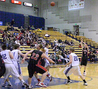 Beau Schlader sinks a 3-pointer in the second half. At left are David Johnson and Devin Schmidt. Photo by Kayla Raymond.