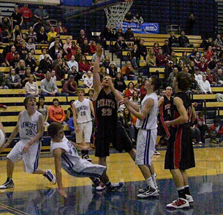 David Johnson goes for a lay-up as Justin Schmidt watches. In the background is Devin Schmidt.