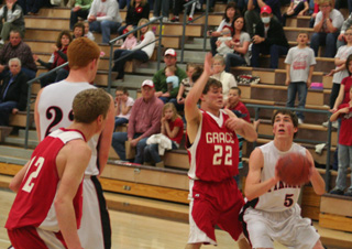 Seth Guyer looks to shoot against Grace. At left is David Johnson.