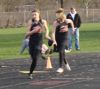 Brandi Gehring, right, has just handed off to Shelby VonBargen in the 4x100 relay. Photo by Kayla Raymond.