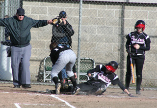 Savanah Prigge is signaled safe at home after a passed ball on this slide as on-deck hitter Kendra Dinning watches in the game against Highland.