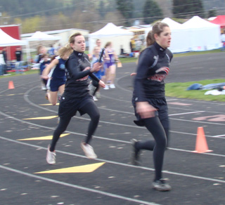 Brandi Gehring is about to hand to Shelby VonBargen in one of the relays. Photo by Kayla Raymond.