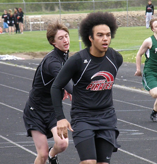 Dylon Bruegeman passes off to Sidney Camara in the 4x200 relay.