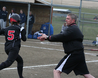 Coach Jeff Martin waves home Megan Sigler as he watches the play in the outfield on Haleigh Schmidts 2-run double.