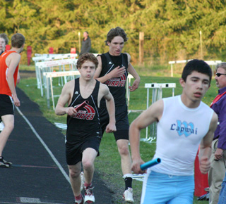Justin Schmidt turns the baton over to Brock Heath in the medley relay in second place. Heath was able to run down the Lapwai runner to finish first.