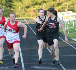 Keely Schmidt hands off to Shelby VonBargen in the medley relay. They finished 4th in the medley but were part of the state qualifying 4x100 and 4x200 relays.