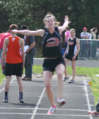 MaKayla Schaeffer soars towards the pit in the triple jump where she broke the school record Friday to win the District Championship in the event.