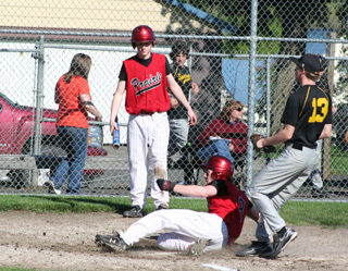 Troy Lorentz slides into home with a run against Timberline as Silas Whitley watches.