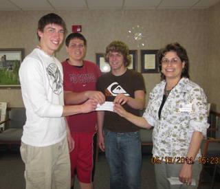 Seth Guyer, Josh Zigler and Michael Karel, PHS HOSA students, accept a check from Collette Schaeffer, St. Marys Hospital Mission Committee, to help underwrite the cost of their upcoming trip to the national HOSA competition.